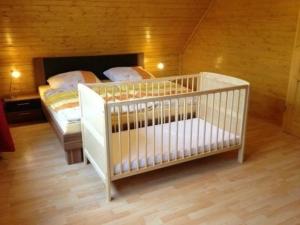 ein Kinderbett in einem Zimmer mit einer Holzwand in der Unterkunft Harzer Blockhaus III in Bad Sachsa