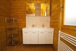 ein Badezimmer mit einem weißen Waschbecken und einem Spiegel in der Unterkunft Harzer Blockhaus III in Bad Sachsa