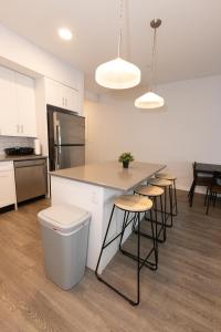 a kitchen with a island with stools and a counter top at Quaint Two-Bedroom Abode mins to NYC in Jersey City