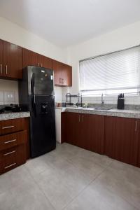 a kitchen with a black refrigerator and wooden cabinets at JudyHouse in Salinas