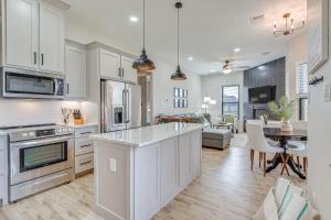 a kitchen with white cabinets and a living room at Northlake Vacation Rental with Pool and Hot Tub Access in Northlake