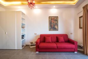 a red couch in a living room with a chandelier at Appartement in Naxos - b58780 in Giardini Naxos