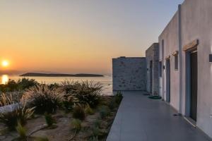 a view of a building with the sunset in the background at Drios Hillhouse in Drios