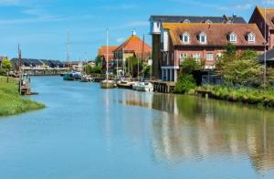 Un río con barcos atracados junto a algunos edificios en The oast @ faversham en Kent