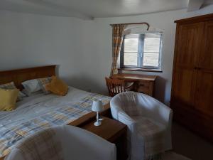 1 dormitorio con 1 cama, escritorio y sillas en The oast @ faversham, en Kent