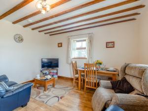 a living room with a table and a blue couch at 2 Bed in Aberystwyth TWLCT in Llanfihangel-y-creuddyn