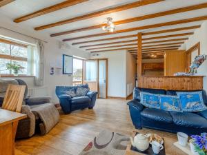 a living room with blue leather furniture and wooden ceilings at 2 Bed in Aberystwyth TWLCT in Llanfihangel-y-creuddyn