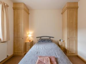 a bedroom with a bed and some wooden cabinets at 2 Bed in Aberystwyth TWLCT in Llanfihangel-y-creuddyn