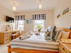 a bedroom with a bed with pillows on it at 3 Bed in Charmouth DC121 in Charmouth