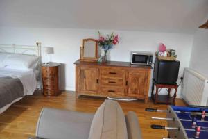 a bedroom with a bed and a dresser with a microwave at Bed@Byways, Holton in Wincanton