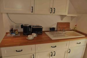 encimera de cocina con fregadero y microondas en Bed@Byways, Holton, en Wincanton
