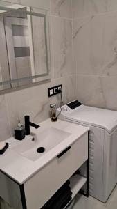 a bathroom with a white sink and a mirror at Apartament Morski nr 4 Baltic Nova in Władysławowo