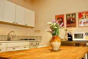 a kitchen with a table with a vase of flowers on it at appartamento la Bastia fra il lago di Garda e Brescia città in Nuvolento