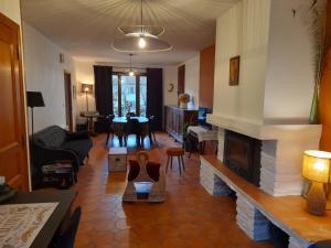 a living room with a fireplace and a dining room at Les Violettes in Mons
