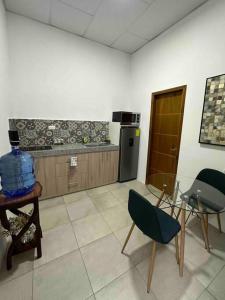 a kitchen with a table and two chairs in a room at Acogedora Suite in Machala