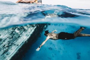 The Zen Den في ثولوسدو: رجل يستلقي في الماء في المحيط