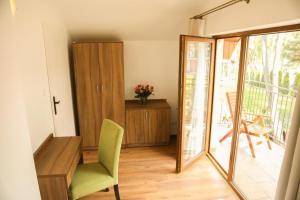 a living room with a green chair and a sliding glass door at Ferienhaus in Dwirzyno mit Privater Terrasse - b48999 in Dźwirzyno