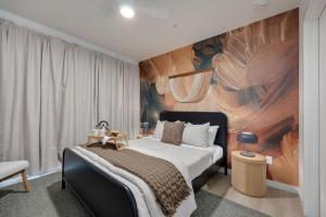 ナッシュビルにあるHyve - Timber Blanc - Walk to Broadwayのベッドルーム1室(壁に絵画が描かれたベッド1台付)