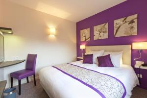 a bedroom with a bed and a purple wall at Le Relais D'arc Et Senans in Arc-et-Senans