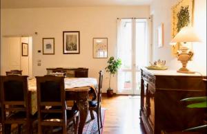 una sala da pranzo con tavolo, sedie e una finestra di Cozy apartment in Palazzo Magnalbo' a Macerata