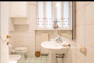 un bagno bianco con lavandino e WC di Cozy apartment in Palazzo Magnalbo' a Macerata Altre 16 foto