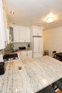 a kitchen with white cabinets and a counter top at Close to NYC - Welcoming & Friendly 2-Bed Home in Union City