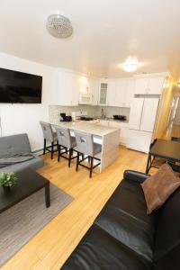 a living room with a table and chairs and a kitchen at Close to NYC - Welcoming & Friendly 2-Bed Home in Union City