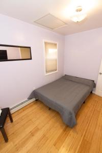 a bedroom with a bed in a white room at Close to NYC - Welcoming & Friendly 2-Bed Home in Union City