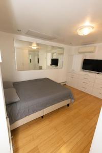 a bedroom with a bed and a flat screen tv at Close to NYC - Welcoming & Friendly 2-Bed Home in Union City