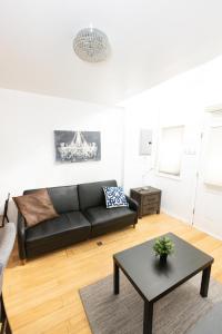 a living room with a black couch and a table at Close to NYC - Welcoming & Friendly 2-Bed Home in Union City