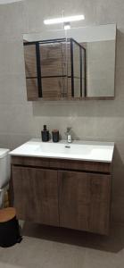 a bathroom with a sink and a mirror at Nouli's Mountain View Haven in Nikiti