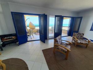 a living room with blue doors and a view of the ocean at Hotel appartment sea view 3 bedrooms 3 toilets 3rd floor free wifi Bellevue village agami alexandria families are preferred available all year days in Alexandria