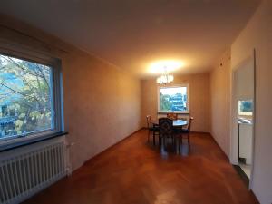 a dining room with a table and chairs and a window at Room in house with good communication in Stockholm