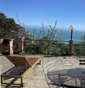 a patio with a table and chairs and the ocean at Agriturismo L'Ulivo E Il Mare in Moneglia