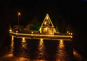 a house with lights on the water at night at Tenta bungalov in Rize