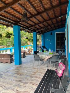 a patio with a table and chairs under a wooden ceiling at Casa Sítio Beija Flor in Guaramiranga