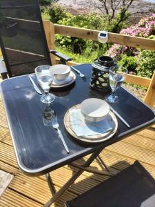 una mesa de picnic negra con vasos y platos. en Sea Breeze cabin, en Donegal