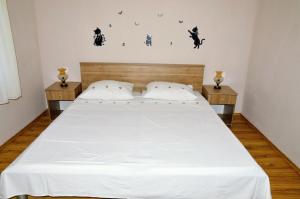 een slaapkamer met een groot wit bed en 2 nachtkastjes bij Ferienwohnung für 6 Personen ca 70 qm in Vinisce, Dalmatien Mitteldalmatien in Vinišće