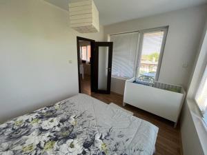 ein Schlafzimmer mit einem Bett und einem großen Fenster in der Unterkunft Oasis2 in Nessebar