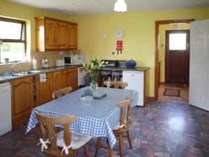 een keuken met een tafel met een blauw en wit tafelkleed bij Sheans Holiday Cottage Killarney by Trident Holiday Homes in Killarney