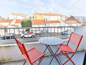 2 sillas y una mesa en el balcón en Appartement cocooning proche centre ville et gare en Les Sables-dʼOlonne