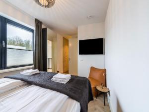 a bedroom with a bed and a large window at Water villa with its own jetty near Harderwijk in Zeewolde