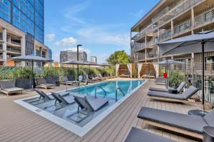 an outdoor swimming pool with lounge chairs and umbrellas at Hyve - Whiskey Trails - Walk to Broadway in Nashville