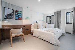 Un dormitorio con una cama, un escritorio y una silla. en Hygge Luxury Apartments, en Cali