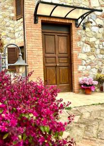 a door of a brick building with pink flowers at Theo House in Siena