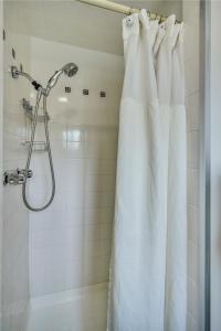 a shower with a white shower curtain in a bathroom at Calistoga Wine Way Inn in Calistoga