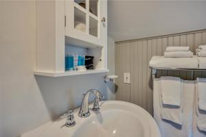 a bathroom with a sink and a shelf with towels at Calistoga Wine Way Inn in Calistoga