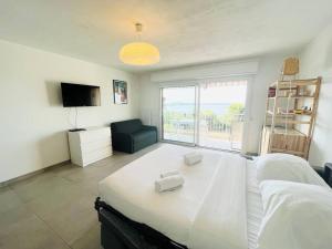 邦多勒Studio Cosy-Vue Mer Panoramique Exceptionnelle的卧室里有一张白色的大床和一扇窗户