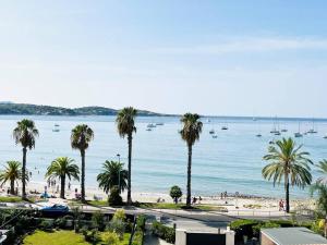 邦多勒Studio Cosy-Vue Mer Panoramique Exceptionnelle的享有棕榈树海滩和水域的景色