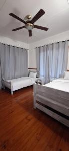 a bedroom with two beds and a ceiling fan at Serenity, Ponta do Ouro in Ponta do Ouro